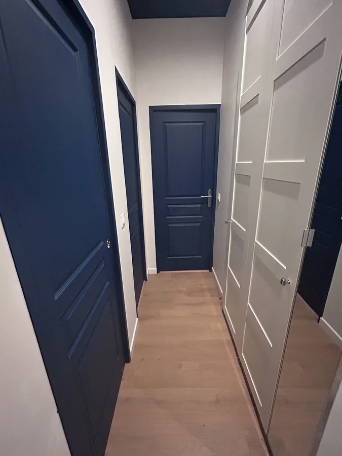 Couloir avec portes bleu nuit et rangement toute hauteur
