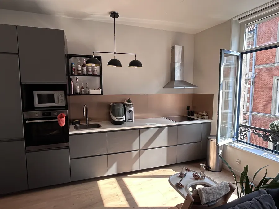 Plan de travail de la cuisine avec évier, plaque à induction et crédence