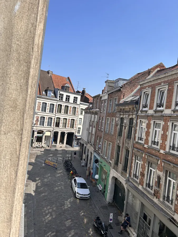 Vue depuis les fenêtres sur les façades anciennes et les pavés du Vieux-Lille